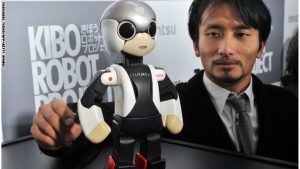 This picture taken on December 19, 2013 shows Japanese robot creator and associate professor of the University of Tokyo, Tomotaka Takahashi (R), chatting to a small humanoid robot named "Mirata", who is the twin brother robot to the world's first astronaut robot "Kirobo" in Takahashi's laboratory at the University of Tokyo. Korobo, the world's first robot astronaut, has begun chatting on December 20, 2013 to the Japanese commander of the International Space Station, in what was being billed as the first conversation of its kind.   Kirobo, a pint-sized android equipped with artificial intelligence and capable of learning how to respond appropriately to humans, even put a marker down for Christmas, telling Koichi Wakata he expected a visit from a certain man bearing gifts.        AFP PHOTO / Yoshikazu TSUNO        (Photo credit should read YOSHIKAZU TSUNO/AFP/Getty Images)