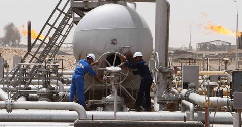 Workers of South Oil Company (SOC) adjust a valve at the Rumaila oil field in Basra Province in this May 24, 2010 file photo. The initial development plan agreed by Exxon Mobil and its partners for Iraq's West Qurna Phase One oilfield included drilling eight new wells and overhauling up to 50 wells this year to boost output. Exxon Mobil wants to leave its flagship Iraqi oil project after upsetting Baghdad by signing a deal last year with the autonomous northern Kurdish region, which the central government deemed illegal, US officials confirmed October 18, 2012. REUTERS/Atef Hassan/Files (IRAQ - Tags: ENERGY BUSINESS)