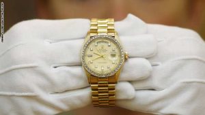 An employee of Christie's auction house poses with a1976 Rolex watch given to Elvis Presley by Colonel Tom Parker which is estimated to sell for £6,000 - £8,000, during a press preview ahead of Christie's Pop Culture sale in London on November 23, 2012.   Christie's Pop Culture sale will take place on November 29 in London. AFP PHOTO / JUSTIN TALLIS        (Photo credit should read JUSTIN TALLIS/AFP/Getty Images)